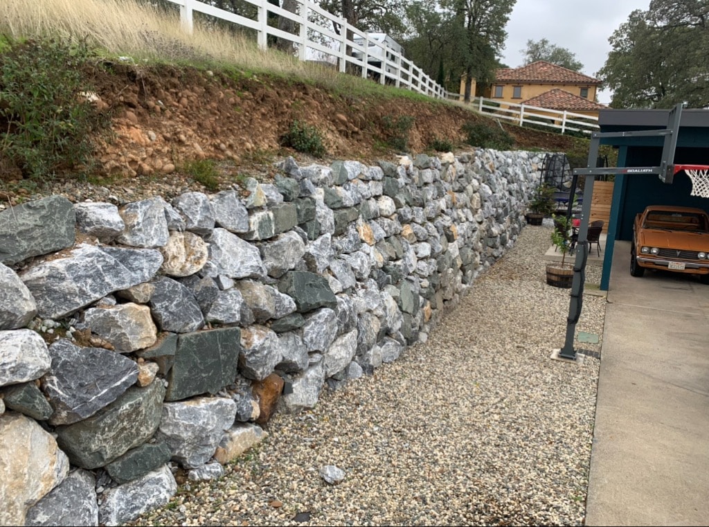 Stone retaining wall along rural property driveway