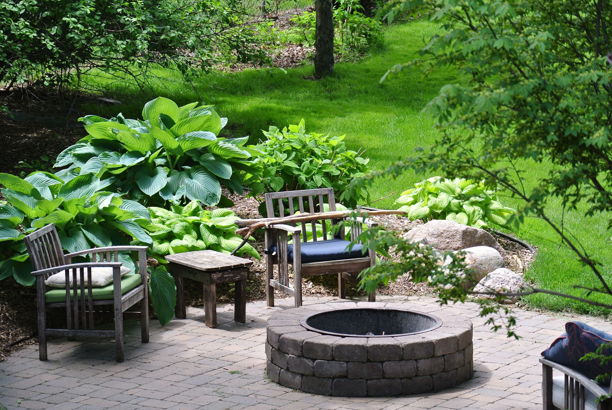 Backyard fire pit patio with seating and garden
