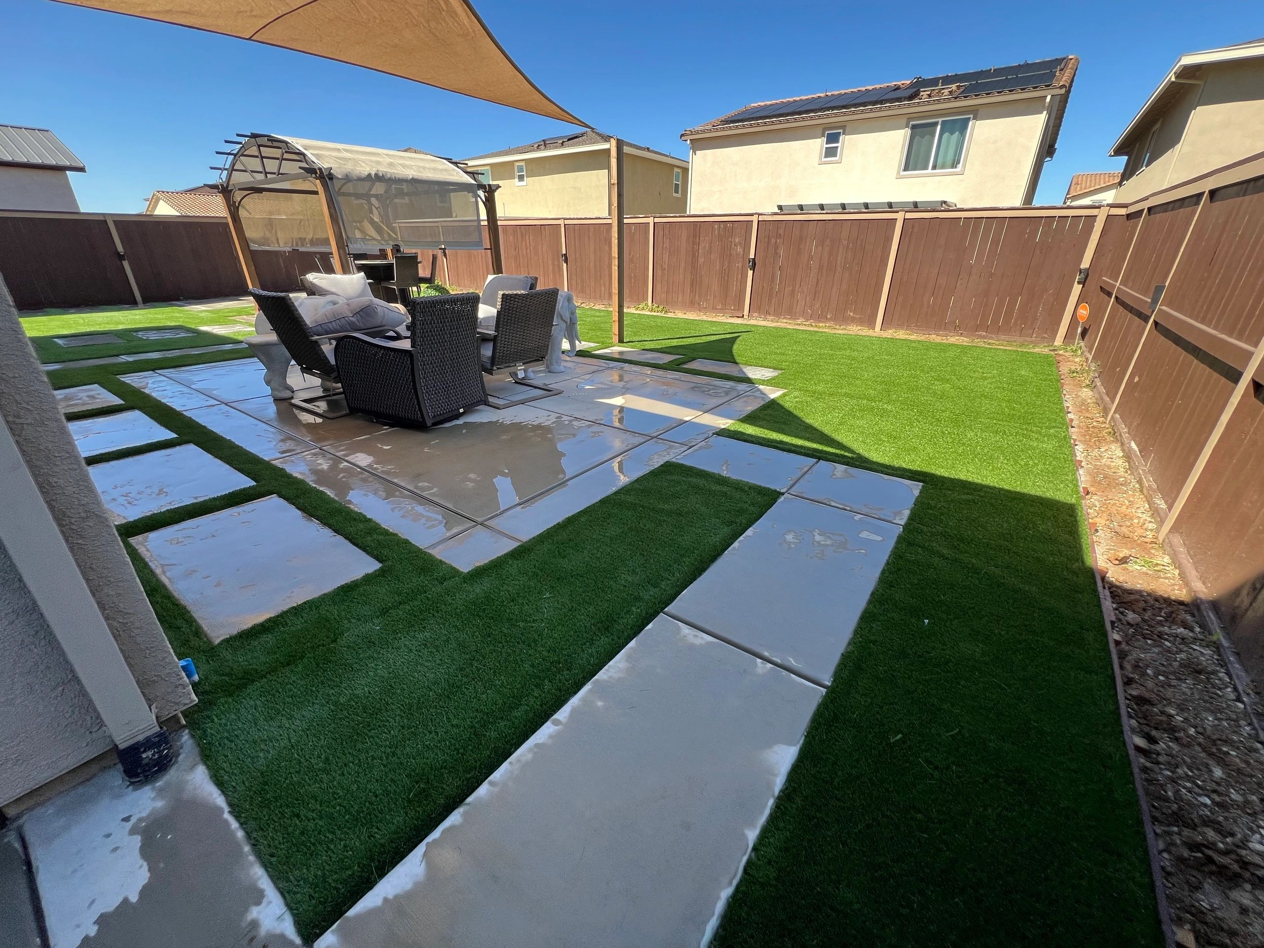 Modern backyard with concrete pavers and artificial turf